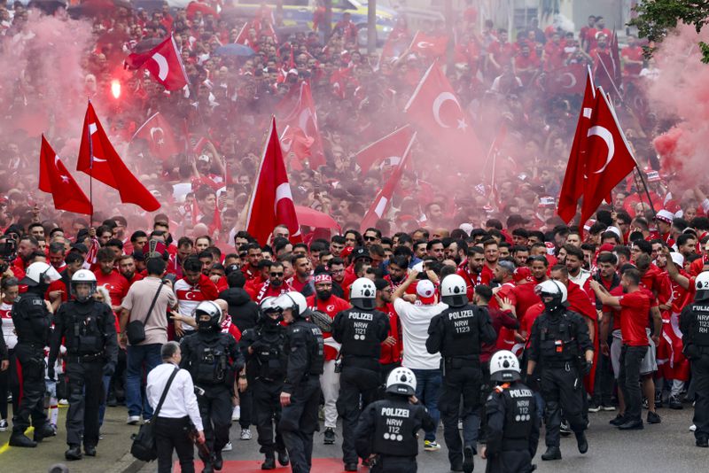 Turkish fans march towards the stadium ahead of a Euro 2024 Soccer Championship Group F match between Turkey and Georgia, in Dortmund, Germany, Tuesday, June 18, 2024. (Christoph Reichwein/dpa via AP)