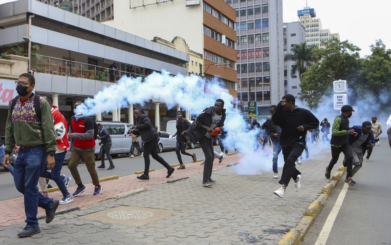 Demonstrators run from police during a protest over proposed tax hikes in a finance bill that is due to be tabled in parliament in Nairobi, Kenya, Thursday, June 20, 2024. Civil society groups say that despite the dozens of arrests, demonstrations and a planned sit-down outside the parliament buildings will continue. (AP Photo/ Andrew Kasuku)