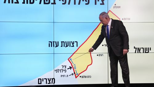 Israeli Prime Minister Benjamin Netanyahu stands before a map of the Gaza Strip, telling viewers that Israel must retain control over the "Philadelphi corridor," a strategic area along the territory's border with Egypt, during a news conference in Jerusalem, Monday, Sept. 2, 2024. The Hebrew on the screen reads, "Philadelphi corridor under Israeli military control." (AP Photo/Ohad Zwigenberg, Pool)