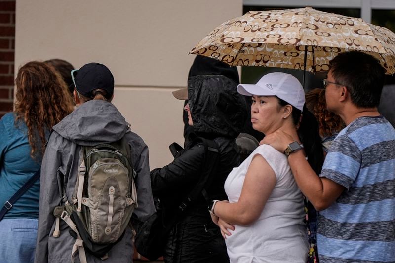 People wait to buy groceries as they stand in line outside an Ingles grocery store in the aftermath of Hurricane Helene, Monday, Sept. 30, 2024, in Asheville, N.C. (AP Photo/Mike Stewart)