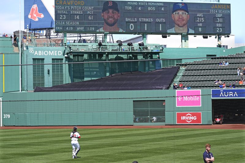 Boston Red Sox catcher Danny Jansen heads to the bullpen to prior baseball game, which was delayed due to rain in June, against the Toronto Blue Jays at Fenway Park, Monday, Aug. 26, 2024, in Boston. Jansen, who was traded by the Blue Jays to the Red Sox on July 27th, is in the line-up against his former team when the delayed game continues Monday afternoon. Jansen will become the first major league player to appear in the same game for both teams. (AP Photo/Charles Krupa)