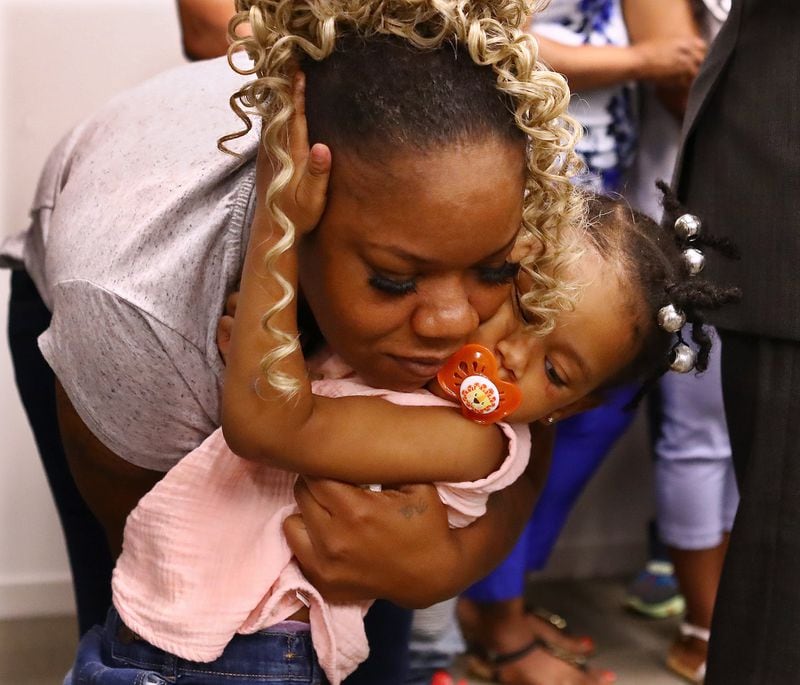 Tomika Miller, the wife of Rayshard Brooks, hugs their daughter Memory, 2, during the family press conference on Monday, June 15, 2020, in Atlanta. Brooks was killed by an APD officer Friday and the heartbroken family is determined that his death spark positive change. Curtis Compton ccompton@ajc.com