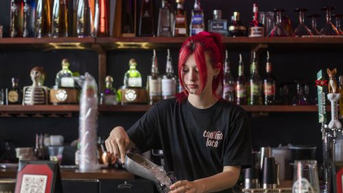 Server Sophie Davis prepares drinks for her customers at Cantina Loca in Alpharetta, one the restaurants owned by the Will Restaurants Investment Group. The owner, Brian Will, has raised wages to attract and retain workers. He says more motivated employees also provide better service, (Alyssa Pointer / Alyssa.Pointer@ajc.com)