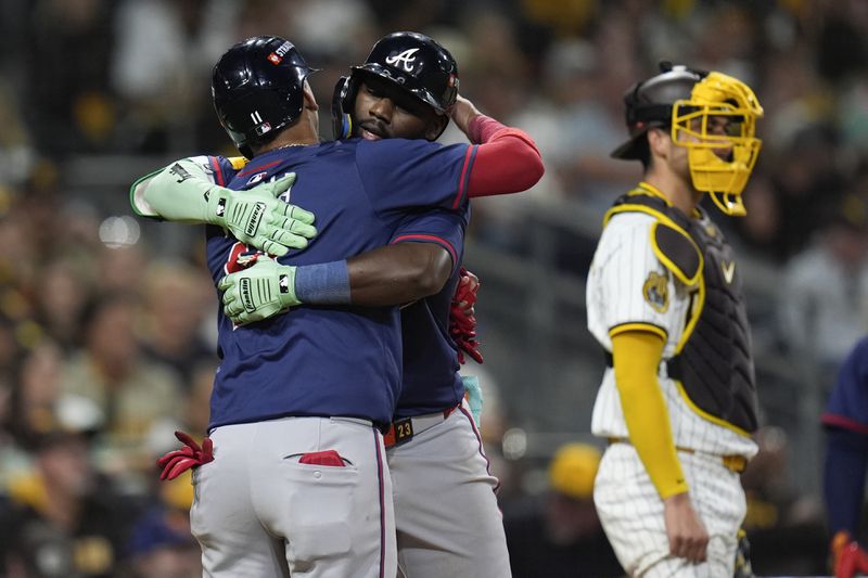 Atlanta Braves' Michael Harris II, center, hugs Orlando Arcia, left, after Harris' two-run home run during the eighth inning in Game 2 of an NL Wild Card Series baseball game against the San Diego Padres, Wednesday, Oct. 2, 2024, in San Diego. (AP Photo/Gregory Bull)