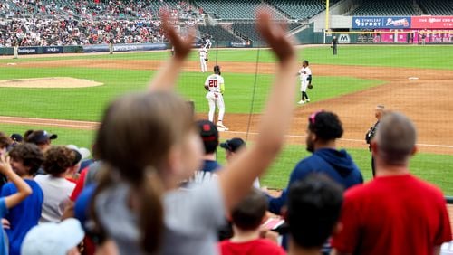 A fan waves during the Braves’ postseason workout at Truist Park in Cobb County on Thursday. (Arvin Temkar / arvin.temkar@ajc.com)