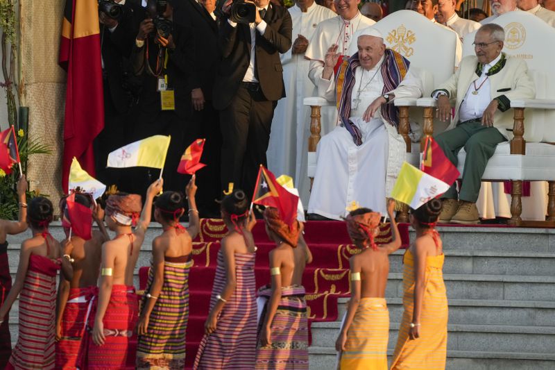 Pope Francis cheers at children in traditional dress as he attends with East Timor's President José Manuel Ramos-Horta, a welcome ceremony outside the Presidential Palace in Dili, East Timor, Monday, Sept. 9, 2024. Pope Francis arrived in East Timor on Monday to encourage its recovery from a bloody and traumatic past and celebrate its development after two decades of independence from Indonesian rule. (AP Photo/Gregorio Borgia)