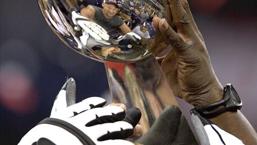 New England players hoist the Lombardi trophy after beating the St. Louis Rams 20-17 to win Super Bowl XXXVI at the Louisiana Superdome, in New Orleans, Louisiana, on Sunday, Feb. 3, 2002.