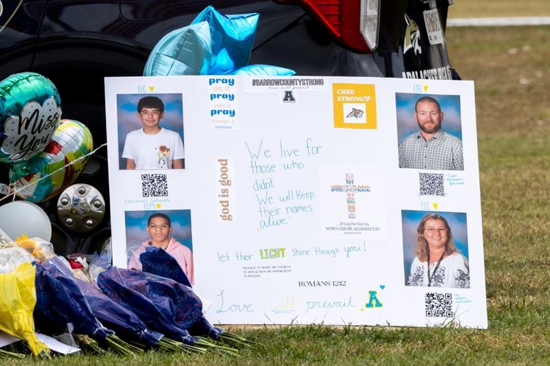 A poster at a memorial displays the photos (clockwise) of Christian Angulo, Ricky Aspinwall, Mason Schermerhorn and Cristina Irimie at Apalachee High School on Friday, Sept. 6, 2024, in Winder, Ga. A 14-year-old Apalachee student is accused of shooting and killing the students and teachers and injuring nine others at Apalachee High School on Wednesday. (Arvin Temkar / AJC)