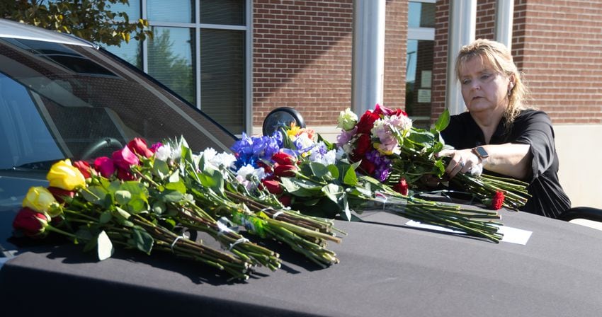 Paulding County Sheriff Lt Tracy Brown leaves flowers on the hood of the patrol car, parked in front of the Paulding County sheriff’s office. Paulding County Deputy Brandon Cunningham was the first Paulding deputy killed in the line of duty. (John Spink/AJC)