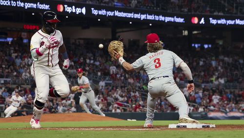 Philadelphia Phillies first baseman Bryce Harper (3) fields the ball to get out Atlanta Braves center fielder Michael Harris II (23) during the ninth inning at Truist Park, Wednesday, August 21, 2024, in Atlanta. The Atlanta Braves lost 3-2. (Jason Getz / AJC)
