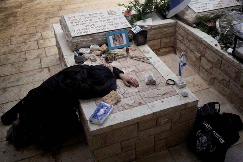 Sara Chen weeps over the grave of her longtime friend, Staff Sergeant Avraham Nerya Cohen, who was killed in action on 7 October. 2023, as Israel marks the one-year anniversary of the Hamas attack on Israel, at the Mount Herzl military cemetery in Jerusalem on Monday, 7 October 2024. (AP Photo/Maya Alleruzzo)