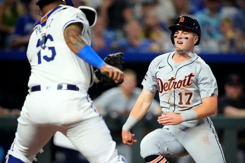 Detroit Tigers' Jace Jung (17) beats the tag by Kansas City Royals catcher Salvador Perez to score on a double by Trey Sweeney during the third inning of a baseball game Wednesday, Sept. 18, 2024, in Kansas City, Mo. (AP Photo/Charlie Riedel)