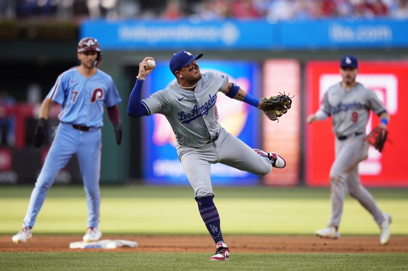Los Angeles Dodgers shortstop Miguel Rojas hangs onto a single by Philadelphia Phillies' Bryce Harper during the third inning of a baseball game, Thursday, July 11, 2024, in Philadelphia. (AP Photo/Matt Slocum)