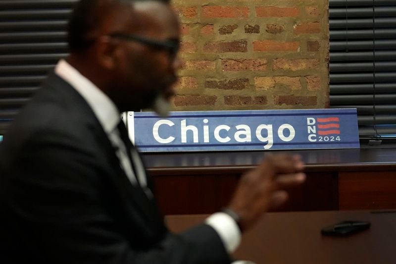 A street sign with the Democratic National Convention acronym featured sits in the campaign office of Chicago Mayor Brandon Johnson as he responds to a question during an interview with The Associated Press on Thursday, Aug. 15, 2024, just days before the start of the Democratic National Convention in Chicago. (AP Photo/Charles Rex Arbogast)