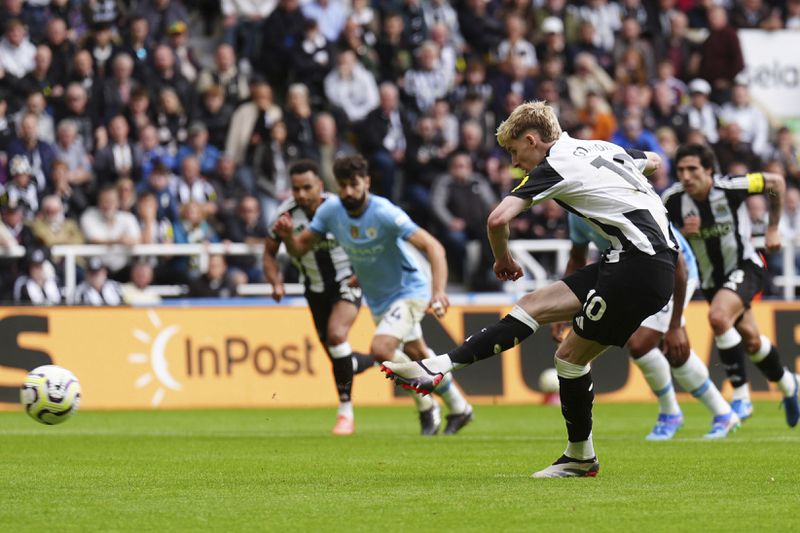 Newcastle United's Anthony Gordon shoots to score the equalizing goal from a penalty spot during the Premier League match between Newcastle and Manchester City, at St James' Park, Newcastle upon Tyne, England, Saturday Sept. 28, 2024. (Owen Humphreys/PA via AP)