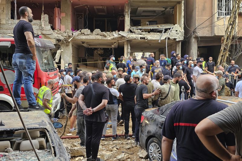 Residents look on as rescuers arrive at the scene of an Israeli missile strike in the southern suburbs of Beirut, Friday, Sept. 20, 2024. (AP Photo/Hassan Ammar)