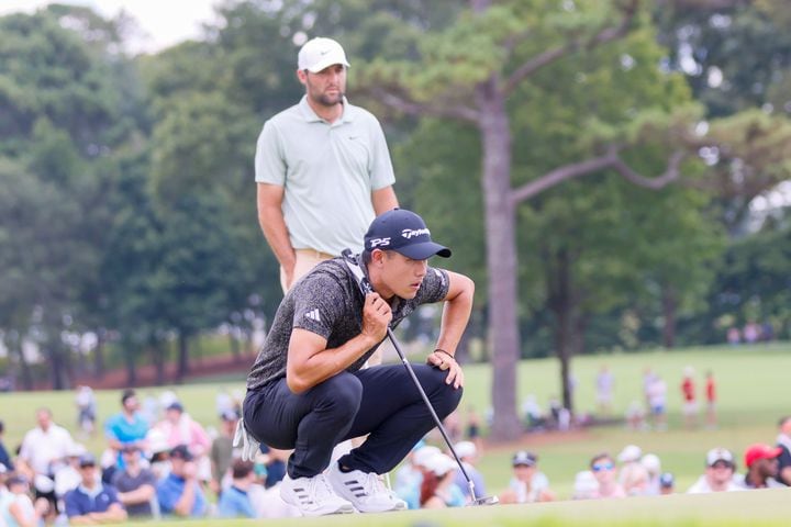 Collin Morikawa aligns his putt as Scottie Scheffler looks on the fifth green during the final round of the Tour Championship at East Lake Golf Club, Sunday, Sept. 1, 2024, in Atlanta.
(Miguel Martinez / AJC)