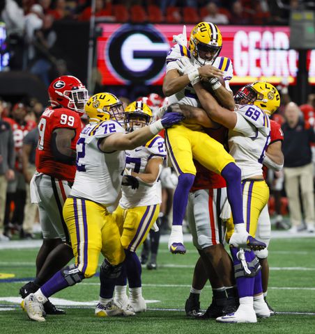 LSU Tigers quarterback Jayden Daniels (5) is stopped by Georgia Bulldogs defenders during the second half of the SEC Championship Game at Mercedes-Benz Stadium in Atlanta on Saturday, Dec. 3, 2022. (Bob Andres / Bob Andres for the Atlanta Constitution)