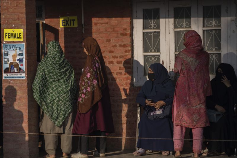 Kashmiri women queue up at a polling booth to cast their vote in Marval, south of Srinagar, Indian controlled Kashmir, Wednesday, Sept. 18, 2024. (AP Photo/Dar Yasin)