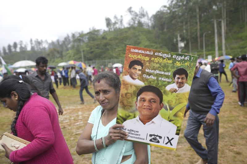 A tea plantation worker carries an election poster showing a portrait of the opposition leader and presidential candidate Sajith Premadasa, during an election rally in Thalawakele, Sri Lanka, Sunday, Sept. 8, 2024. (AP Photo/Eranga Jayawardena)