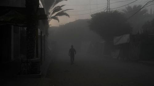 A Palestinian walks on a smoke-filled street after an Israeli airstrike in Deir al Balah, Gaza Strip, Tuesday, Aug. 6, 2024. (AP Photo/Abdel Kareem Hana)