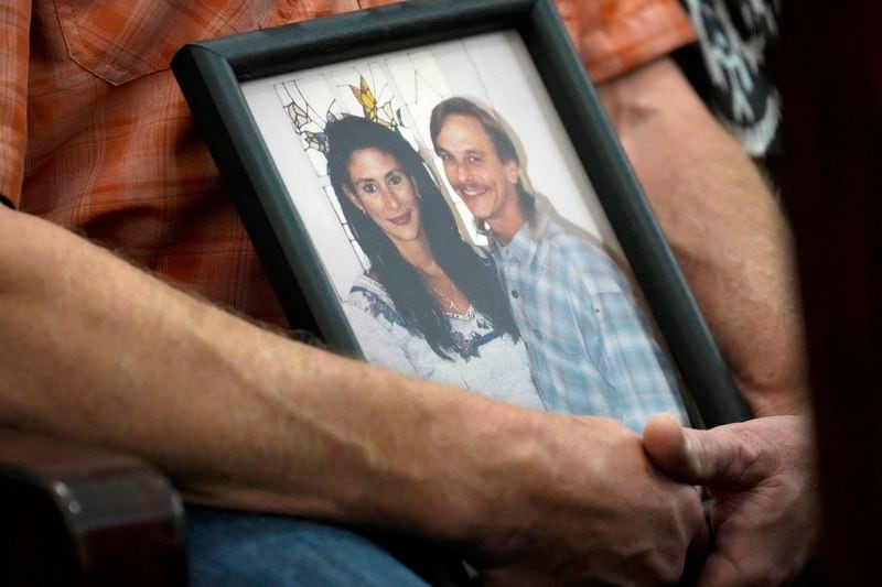 Family members of Dennis Tuttle and Rhogena Nicholas bring a photograph of the couple to the trial of retired Houston Police Department officer Gerald Goines Monday, Sept. 9, 2024 at Harris County Criminal Courthouse in Houston. Goines' trial on two felony murder charges in the January 2019 deaths of Tuttle and Nicholas began Monday. (Yi-Chin Lee/Houston Chronicle via AP)