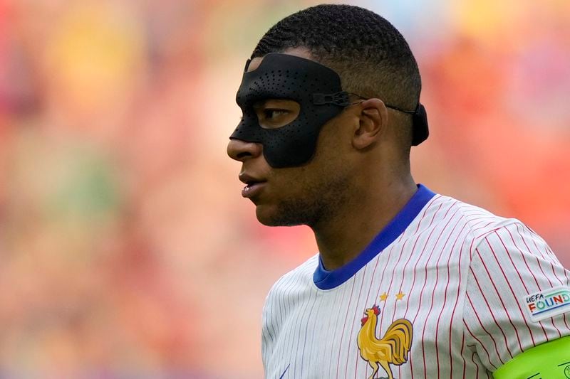 FILE - Kylian Mbappe of France wears a face mask during a round of sixteen match between France and Belgium at the Euro 2024 soccer tournament in Duesseldorf, Germany, on July 1, 2024. Kylian Mbappé has had more masks than goals at Euro 2024. Widely regarded as the heir to Lionel Messi and Cristiano Ronaldo as soccer's biggest icon, the France striker is struggling with his peripheral vision due to the protective face covering he has been fitted with since breaking his nose at the start of the European Championship.(AP Photo/Martin Meissner)