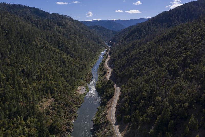 FILE - The Klamath River winds runs along Highway 96 near Happy Camp, Calif., June 7, 2021. (AP Photo/Nathan Howard, File)