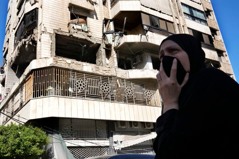 A woman reacts in front an apartment in a multistory building hit by Israeli airstrike, in central Beirut, Lebanon, Thursday, Oct. 3, 2024. (AP Photo/Hussein Malla)