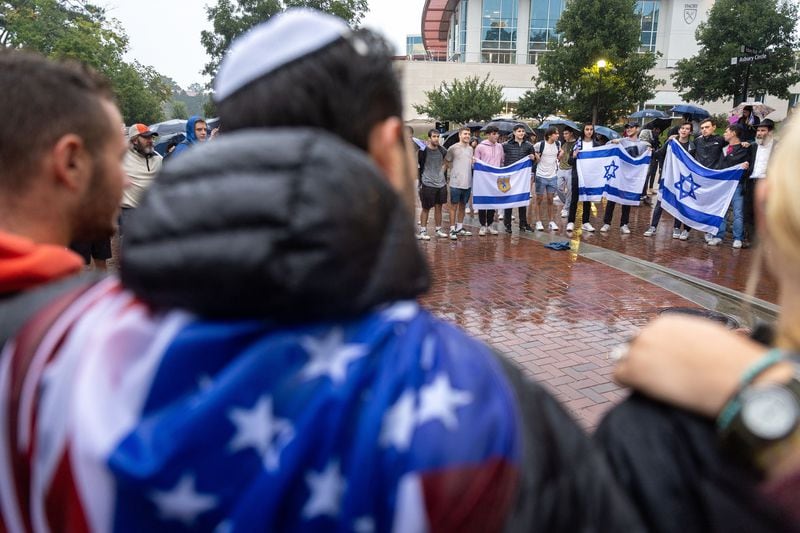 Attendees embrace and sing Jewish songs after a vigil for Israel at Emory University in Atlanta on Wednesday, Oct. 11, 2023. Arvin Temkar/The Atlanta Journal-Constitution/TNS