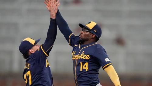 Milwaukee Brewers shortstop Willy Adames (27) and third base Andruw Monasterio (14) celebrate after defeating the Atlanta Braves in a baseball game, Wednesday, Aug. 7, 2024, in Atlanta. (AP Photo/John Bazemore)