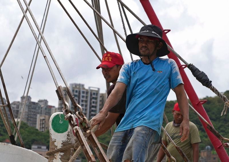 Workers tighten boats with ropes before Typhoon Krathon arrives, at a harbor in Keelung, Taiwan, Monday, Sept. 30, 2024. (AP Photo/Johnson Lai)