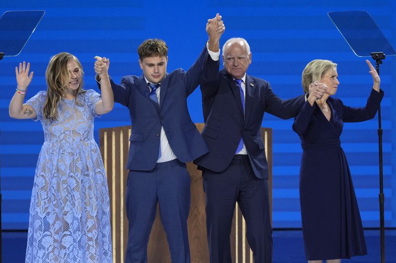 Democratic vice presidential nominee Minnesota Gov. Tim Walz, second from right, poses with his wife Gwen Walz, from right, son Gus Walz and daughter Hope Walz after speaking during the Democratic National Convention Wednesday, Aug. 21, 2024, in Chicago. (AP Photo/J. Scott Applewhite)