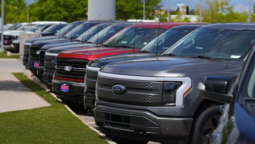 FILE - A line of unsold 2024 F150 and Lightning electric pickup trucks sit at a Ford dealership Sunday, May 19, 2024, in Denver. Investors are punishing auto company stocks this week, Thursday, July 25, after second-quarter earnings exposed industrywide issues of slowing sales and high prices in the face of huge capital investments in electric and gas vehicles. (AP Photo/David Zalubowski, File)