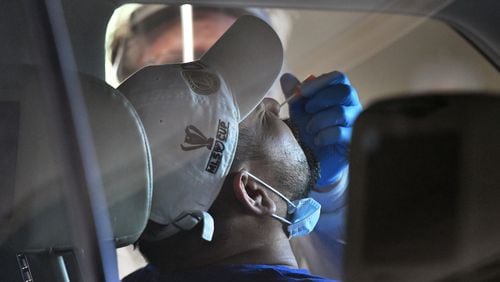 April 22, 2020 Duluth - A medical professional collects a nasal swab from a potential COVID-19 patient at a drive-through COVID-19 testing site for anyone who is experiencing symptoms at the Infinite Energy Center in Duluth on Wednesday, April 22, 2020. A drive-through COVID-19 testing center is open in Gwinnett County for anyone who is experiencing symptoms  â with no doctorâs orders necessary. The Gwinnett, Newton and Rockdale County Health Department conducted 800 tests at the event venue, its second large-scale testing event in a week. (Hyosub Shin / Hyosub.Shin@ajc.com)