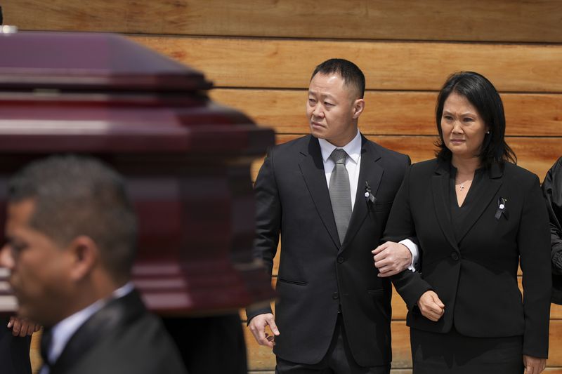 Keiko Fujimori, right, and her brother Kenji stand by as pallbearers carry the coffin of their father, former President Alberto Fujimori, out of Keiko's home the day after he died in Lima, Peru, Thursday, Sept. 12, 2024. (AP Photo/Guadalupe Pardo)