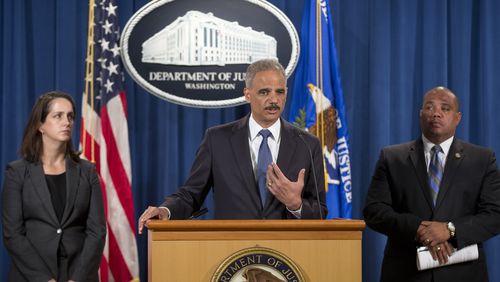 FILE - Attorney General Eric Holder, center, speaks during a news conference at the Justice Department in Washington, Thursday, Sept. 4, 2014, to announce the Justice Department's civil rights division will launch a broad civil rights investigation in the Ferguson, Mo., Police Department. Joining Holder are Molly Moran, left, Acting Assistant Attorney General for Civil Rights Division, and Ronald Davis, right, Dir. of the Office of Community Oriented Policing Services (COPS). (AP Photo/Pablo Martinez Monsivais, File)