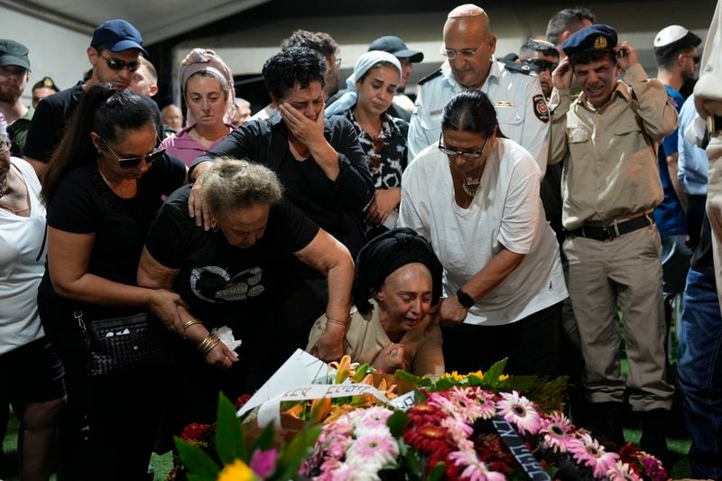 The mother, center, of Petty Officer 1st Class David Moshe Ben Shitrit, who was killed on a Hezbollah attack, mourns during the funeral of her son at the Mount Herzl military cemetery in Jerusalem, Sunday, Aug. 25, 2024. (AP Photo/Ohad Zwigenberg)