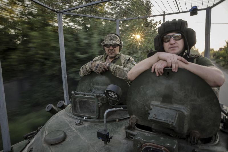 In this photo provided by Ukraine's 24th Mechanised Brigade press service, servicemen of 24th mechanised brigade ride a BRM1k infantry fighting vehicle near Chasiv Yar town, in Donetsk region, Ukraine, Saturday Aug. 17, 2024. (Oleg Petrasiuk/Ukrainian 24th Mechanised Brigade via AP)