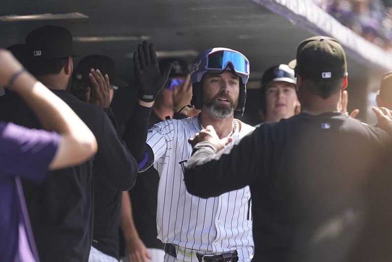 Colorado Rockies' Jake Cave, center, is congratulated as he returns to the dugout after hitting a two-run home run off Atlanta Braves relief pitcher Luke Jackson in the eighth inning of a baseball game Sunday, Aug. 11, 2024, in Denver. (AP Photo/David Zalubowski)