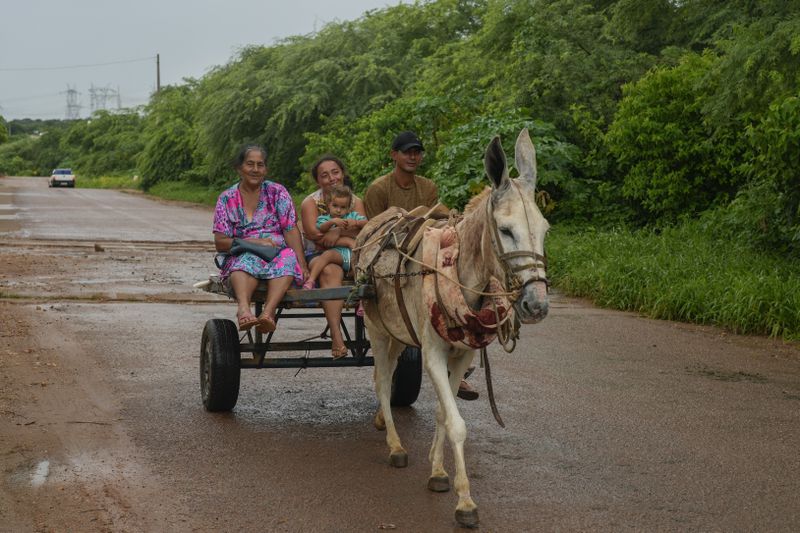 A family rides a donkey carriage in Sumidouro, Piaui state, Brazil, Wednesday, March 13, 2024. (AP Photo/Andre Penner)