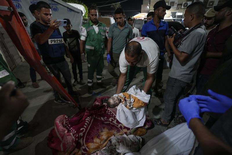 EDS NOTE: GRAPHIC CONTENT - A Palestinian medic moves a child killed in an Israeli bombardment on the Gaza Strip to the morgue of Al Aqsa hospital in Deir al Balah, central Gaza Strip, on Sunday, May 26, 2024. (AP Photo/Abdel Kareem Hana)