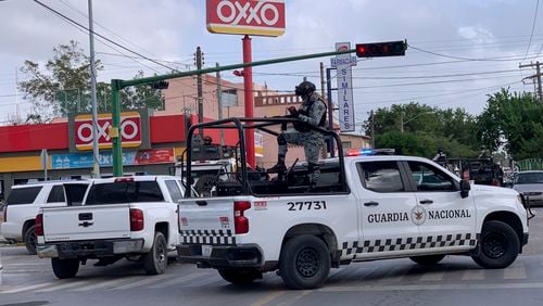 Officers of Mexican National Guard stand on guard near to a Oxxo grocery shop in Matamoros, Mexico, Tuesday, July 30, 2024. Even Mexico's largest corporations are now being hit by demands for protection payments from drug cartels, and gangs are increasingly trying to control the sales, distribution and pricing of certain goods. (AP Photo/Veronica Cisneros)