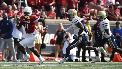 Louisville tight end Jamari Johnson (11) runs from the defense of Georgia Tech linebacker Trenilyas Tatum (0), center, and defensive back Taye Seymore (7) during the first half of an NCAA college football game in Louisville, Ky., Saturday, Sept. 21, 2024. The Braves won 6-2. (AP Photo/Timothy D. Easley)