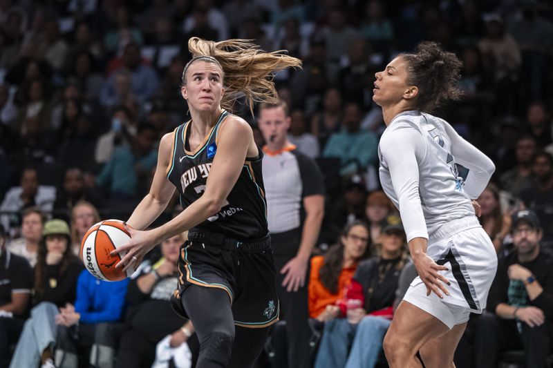 New York Liberty guard Sabrina Ionescu, left, is defended by Las Vegas Aces forward Alysha Clark, right, during the first half of a WNBA basketball second-round playoff game, Sunday, Sept. 29, 2024, in New York. (AP Photo/Corey Sipkin)