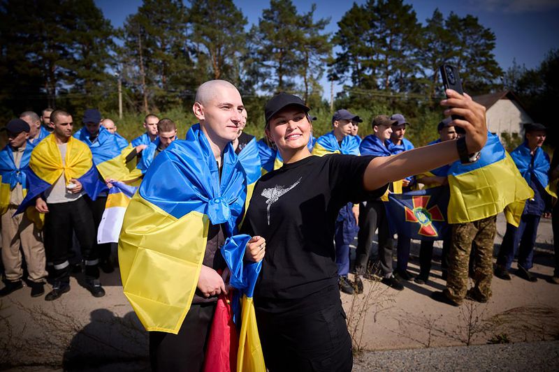 A Ukrainian poses for a selfie as he is greeted after being released in a prisoner exchange at an undisclosed location in Ukraine, Saturday Sept. 14, 2024. (Ukrainian Presidential Press Office via AP)