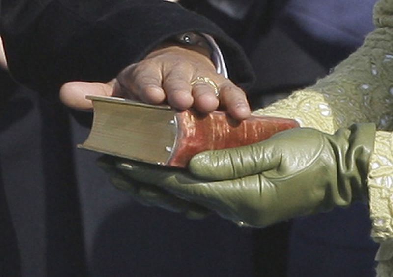 President Barack Obama rests his hand on President Lincoln's Inaugural Bible as  his wife Michelle Obama holds it as he takes the oath of office at the U.S. Capitol in Washington on Jan. 20, 2009.