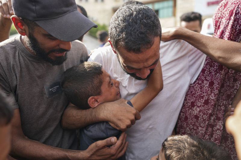 A Palestinian man, center, who was arrested in the Gaza Strip by the Israeli military and released through the Kissufim crossing point is welcomed by relatives at a hospital in Deir al Balah, central Gaza Strip on Monday, July 1, 2024. (AP Photo/Abdel Kareem Hana)