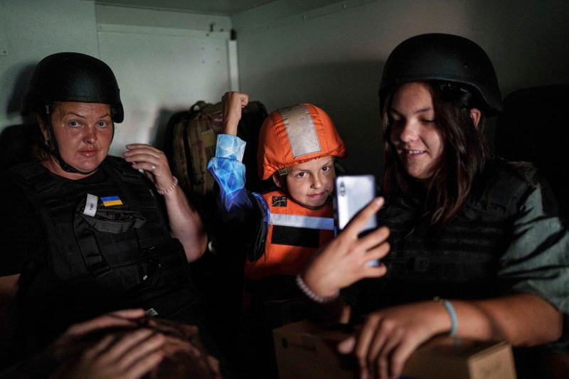 Maryna Scherbyna, left, and her children, 9 year old Bohdan Scherbyna and 14 year old Angelina Scherbyna ride inside an armoured van belonging to the emergency service Fenix team to be evacuated as local people are moved from Selidove to safe areas, in Pokrovsk, Donetsk region, Ukraine, on Tuesday, Aug. 20, 2024. (AP Photo/Evgeniy Maloletka)