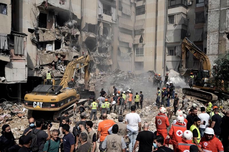 FILE- Emergency workers use excavators to clear the rubble at the site of Friday's Israeli strike in Beirut's southern suburbs, Saturday, Sept. 21, 2024. (AP Photo/Bilal Hussein, File)